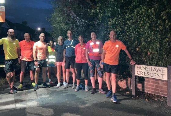 Group of runners mid-effort during One Kilometer Reps